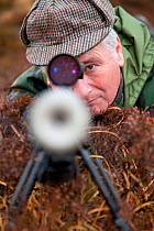 Deer stalker looking through telescopic lens of gun, deer stalking, Assynt Foundation, Glencansip Estate, Assynt, Sutherland, Scotland, January 2011