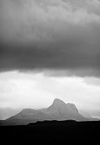 Silhouette of Stac Pollaidh against storm sky, viewed from Tanera More, Coigach and Assynt, Sutherland, Scotland, UK, July 2011