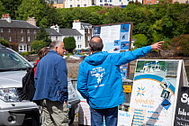 Boat operator touting for business with photographs of introduced Sea eagles, Portree, Skye, Inner Hebrides, Scotland, UK, June 2011