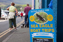 Tourist signs promoting boat trips and tourist exhibits based around the presence of White tailed sea eagles, Portree, Skye, Inner Hebrides, Scotland, UK, June 2011. 2020VISION Book Plate.