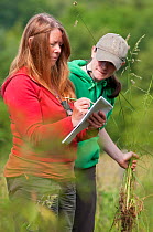 Participants on 'Identifying grasses, sedges and rushes' course, learn from expert, Margaret Howells, at Denmark Farm Conservation Centre, Lampeter, Wales, UK. June 2011. (Model released)