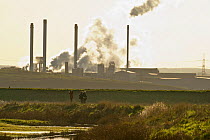 Birdwatchers in foreground with Kemsley Paper Mill in background, Kent, UK, March 2011