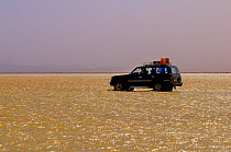 Modern vehicle driving across Karoum salt lake, Danakil depression,  northern Ethiopia, February 2009