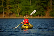 Rear view of a 6 year boy kayaking on Walden Pond, Massachusetts, USA, model released, May 2007