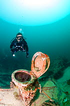Scuba diver exploring wreck of small yacht sunk in a hurricane. Grenada, West-Indies, Caribbean. Model released.