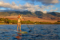 Surf instructor Tara Angioletti on a stand-up paddle board off Canoe Bearch, Maui, Hawaii. Model released.