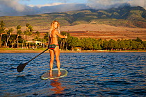 Surf instructor Tara Angioletti on a stand-up paddle board off Canoe Bearch, Maui, Hawaii. Model released.