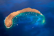 Molokini Crater, aerial shot of the crescent shaped islet at mid-morning with charter boats. Maui, Hawaii., June 2011.