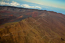 An aerial view across Haleakala Crater showing Ka Lu'u o ka O'o Cone and the last few miles of the road leading to the summit and 'Science City'. Haleakala National Park, Maui's dormant volcano, Hawai...