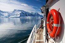 The 'Golden Fleece' (base ship for BBC film crew) passing up the coast of the Antarctic Peninsula, Antarctica, January 2009, Taken on location for BBC Frozen Planet series