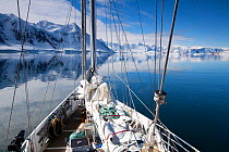 The 'Golden Fleece' (base ship for BBC film crew) passing up the coast of the Antarctic Peninsula, Antarctica, January 2009, Taken on location for BBC Frozen Planet series