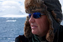 Doug Allan, cameraman, looking for Killer whales (Orcinus orca) in Antarctica.  Taken on location for BBC Frozen Planet series, January 2009