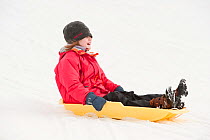 Girl on sledge, Angus, Scotland, UK, January 2010, model released