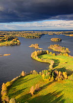 Dark skies over the sunlit 'sacred lake' Puhajarv. Estonia, Europe, October 2010.