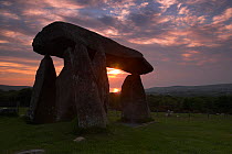Stones of Pentre Ifan, a megalithic Burial Chamber / Cromleck / Quiot at sunset with sun reflected in Cardiganshire Bay in the background, nr Newport, Pembrokeshire, Wales, UK, June 2010