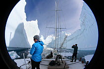 Camera lens view of crew on board the 'Golden Fleece' in the centre of a horseshoe shaped iceberg off the Antarctic Peninsula, Antarctica, February 2009, Taken on location for BBC Frozen Planet series