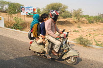 Indian family of four people travelling together on scooter, Uttar Pradesh, India