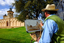 Painter working in front of Cos d'Estournel castle in Bordeaux region, Aquitaine, Gironde, France. September.