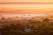 Dawn mist over landscape, Michelham Priory viewed from Wilmington Hill, Wilmington, South Downs National Park, East Sussex, England, UK, July 2011