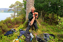 RSPB officer with climbing gear at foot of nesting tree of White-tailed sea eagle (Haliaeetus albicilla), Beinn Eighe NNR, Wester Ross, Scotland, UK, June 2011