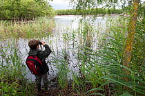 Boy bird watching on family visit to the Westhay Nature Reserve, Somerset Levels, UK, June 2011, model released