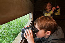 Boy birdwatching on family visit to the Westhay Nature Reserve, Somerset Levels, UK, June 2011, model released