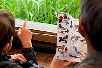 Family in bird hide on visit to the Westhay Nature Reserve, Somerset Levels, UK, June 2011, model released