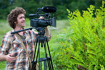 Cameraman Will Bolton filming the release of Exmoor ponies at Street Heath for conservation grazing, Somerset Levels, UK, June 2011, model released
