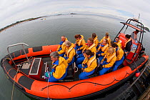 Group of tourists wearing waterproof clothing and life jackets in zodiac boat for seabird safari tour around Bass Rock, North Berwick, Firth of Forth, Lothian, Scotland, UK, August 2011