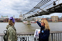 RSPB volunteer Linda Mably talking to member of public about peregrines beneath Millenium Bridge. RSPB 'Date With Nature Event' for learning about urban Peregrine falcon, Tate Modern, South Bank, Lond...
