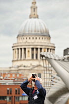 RSPB volunteer watches peregrine falcons with St Paul's Cathedral in background, RSPB 'Date With Nature Event' for learning about urban Peregrine falcon, Tate Modern, South Bank, London, UK, September...