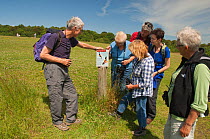 Hikers reading information sign on the Red Kite trail in the Urban Red Kite area of the Derwent Valley, Gateshead, Tyne and Wear, UK, on the edge of Tyneside following on from the 'Northern Kites' re-...