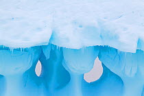 Windows in an iceberg at the 'iceberg graveyard'. Near Pleneau Island, Antarctic Peninsula, Antarctica, January.
