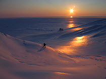 Man walking in vast icy wilderness. Kong Karl's Land, Svalbard, Norway, April. Freeze frame book plate page 17.