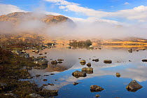 Clouds, mirror reflections and mist slowly clearing the mountains on Loch na h Achlaise, Glen Coe, Rannoch Moor, Highland, Scotland, UK, April 2011