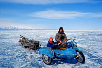 Cameraman Doug Allan on location in Lake Baikal, Siberia, with seal hunter and motorbike with sidecar pulling sledge. April 1989, Cover image of Freeze Frame