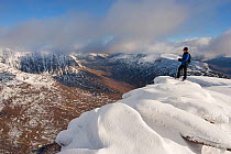 Hillwalker admiring the view from the summit of Tom na Gruagaich in winter, Beinn Alligin, Torridon, Scotland, UK, February 2010 Model Released. 2020VISION Exhibition. 2020VISION Book Plate. Did you k...