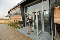 Birdwatcher entering a viewing hide on an organised birdwatching event led by RSPB PR Officer Howard Vaughan, Rainham Marshes RSPB Reserve, RSPB Greater Thames Futurescapes Project, Rainham, Essex, UK...