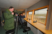 Birdwatchers looking at birds from a viewing hide on an organised birdwatching event led by RSPB PR Officer Howard Vaughan, Rainham Marshes RSPB Reserve, RSPB Greater Thames Futurescapes Project, Rain...