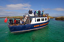 Tourists on board the Sea Life Surveys vessel Sula Beag, Cairns of Coll, Inner Hebrides, Scotland, UK, July 2011