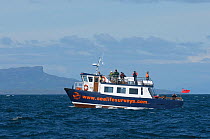 Sea Life Surveys vessel Sula Beag at sea with tourists looking for wildlife near the Isle of Eigg, Inner Hebrides, Scotland, UK, July 2011