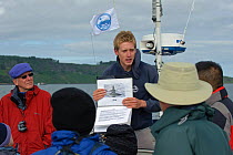 Sea Life Surveys guide briefing tourists on whale identification on board Sula Beag, a dedicated wildlife watching boat, Inner Hebrides, Scotland, UK, July 2011