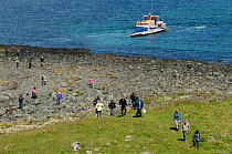 Wildlife tourists landing on island of Lunga in the Treshnish Isles, Inner Hebrides, Scotland, UK, July 2011