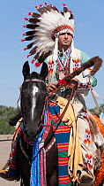 A traditionally dressed Crow Indian man rides a quarter horse during the parade at the annual Indian Crow Fair, Crow Agency, near Billings, Montana, USA, August 2011