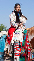 A traditionally dressed Crow Indian woman rides a paint horse during the parade, at the annual Indian Crow Fair, at Crow Agency, near Billings, Montana, USA, August 2011