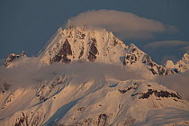 Mount Wright covered in snow with small clouds, Glacier Bay National Park, Alaska, USA, May 2011