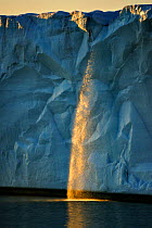 Ice cliff and waterfall catching evening light. Austfonna Polar Ice Cap, Svalbard, Norway, August 2011.
