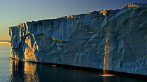 Waterfall and ice cliff catching evening light. Austfonna Polar Ice Cap, Svalbard, Norway, August 2011.
