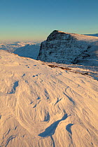 Sastrugi / irregular grooves and shapes in snow caused by wind erosion and deposition, on Ben More Coigach in winter, Coigach, Wester Ross, Scotland, UK, December 2010