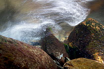 An underwater view of a mountain stream, showing water turbulence around rocks, Snowdonia NP, Gwynedd, Wales, UK, December